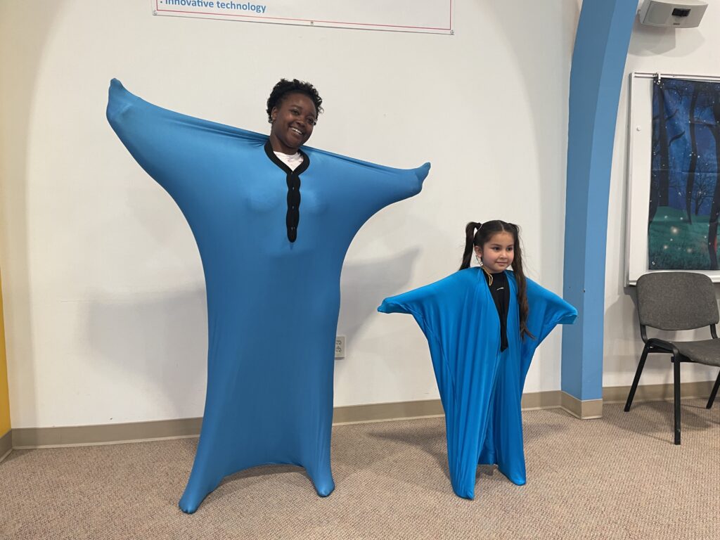 Weingarten Children's Center Talk2Me logo worn by para educator JaLa and student.